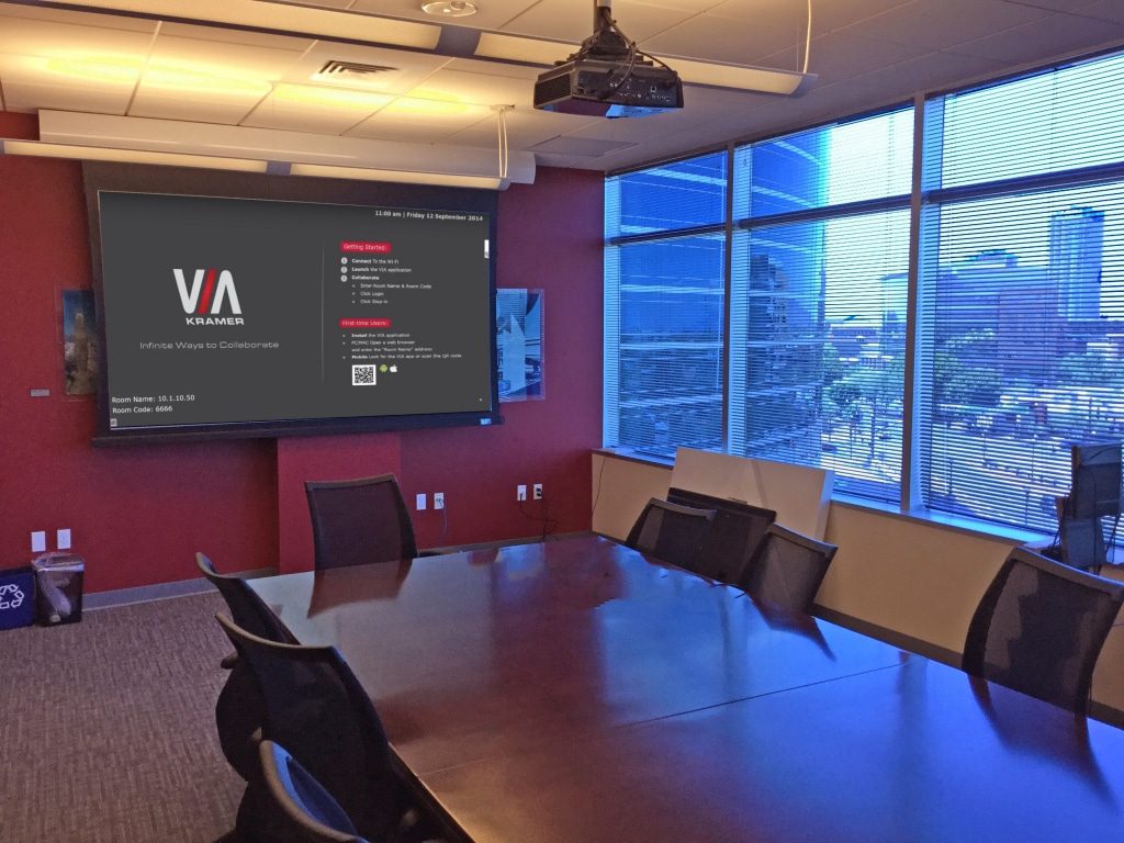 Conference Room With Vivitek Projector and Screen Innovations Motorized Screen. The VIA Campus Wireless Collaboration Device Home Page is Shown on the Screen. 